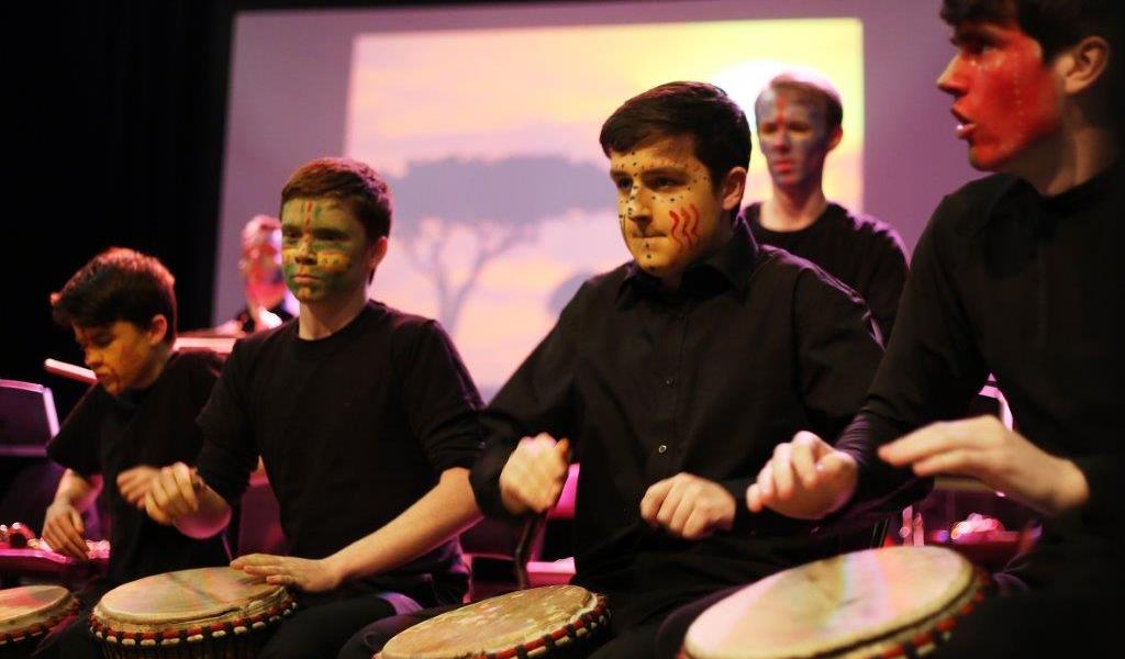 Image of African drumming workshop featuring pupils with facepaint