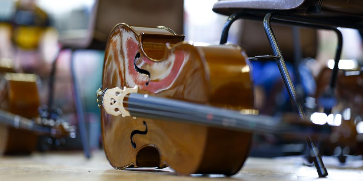 cello on floor in orchestra rehearsal
