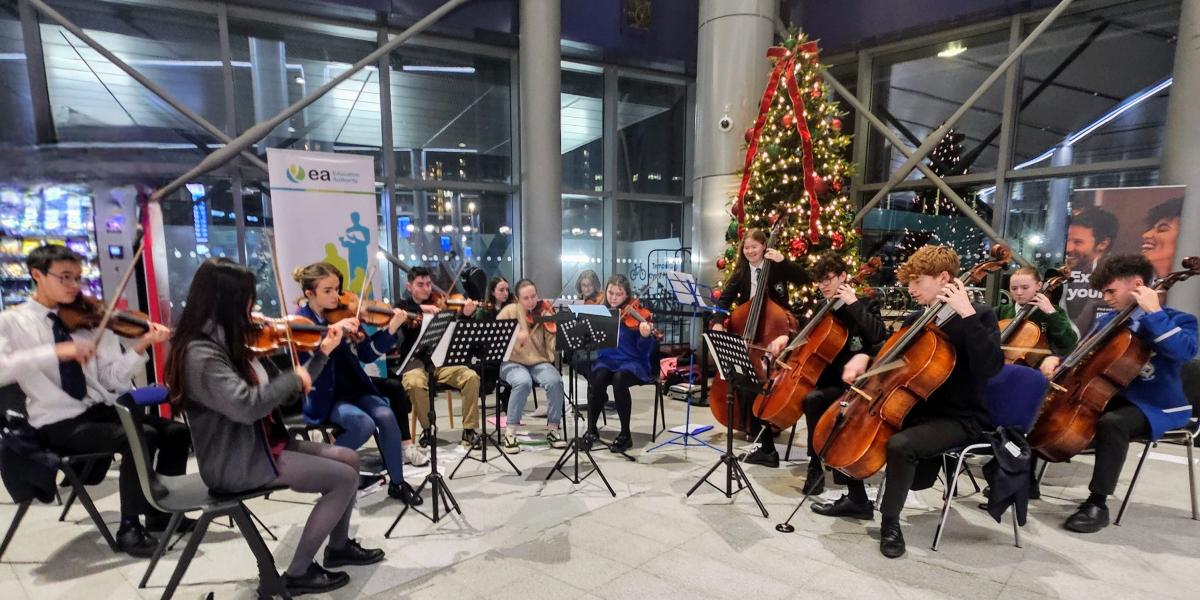 Children and young people playing string instruments at Christmas