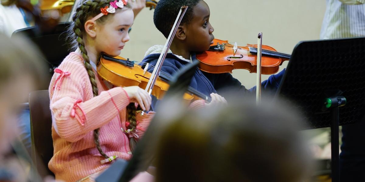 Young musicians performing in a string orchestra rehearsal
