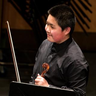young violinist on stage in concert