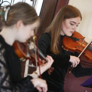 string musicians performing as part of quartet