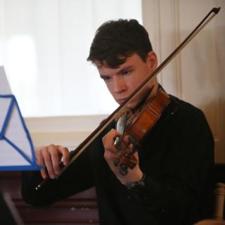 string musician performing as part of quartet