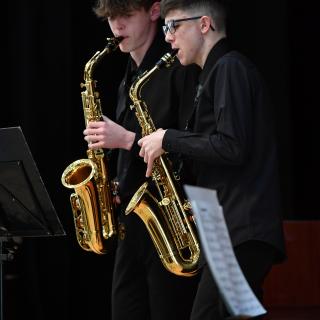 Two saxophone players standing during gig