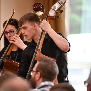 Double bass section performing in youth orchestra concert