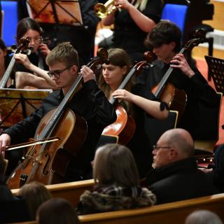 Cello section performing in youth orchestra