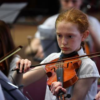 Viola player performing in youth orchestra concert