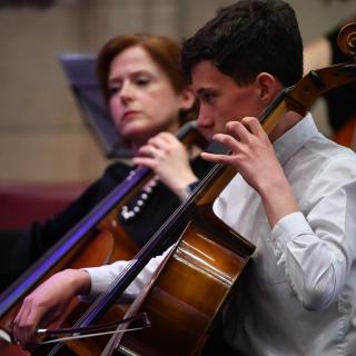 Cellist playing in youth orchestra concert