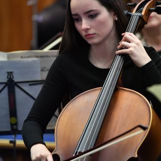 Cellist playing in youth orchestra concert