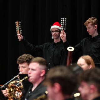 Youth orchestra in concert with percussion players playing Christmas Bell trees