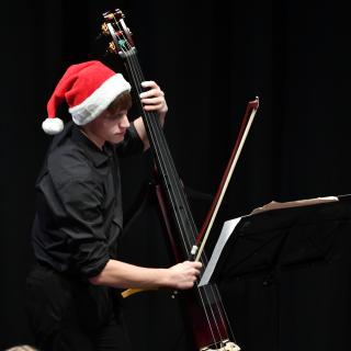 Double Bass player on stage in Christmas hat