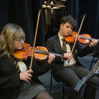 Violin players from String Orchestra in concert in Strule Theatre