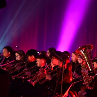 Brass section in concert with pink lighting