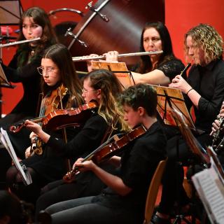 Young musicians performing in youth orchestra concert