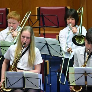 young musicians performing in wind band concert
