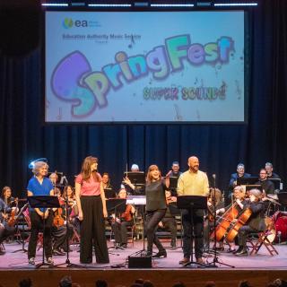 Musical Pathways staff and Staff orchestra on stage at Millennium Forum