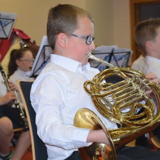 Young French Horn player performing in concert