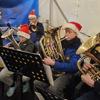 Musicians wearing 'Santa' hats playing brass instruments.