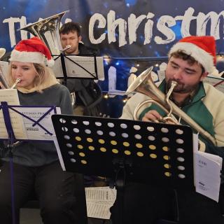 Musicians wearing 'Santa' hats playing brass instruments.