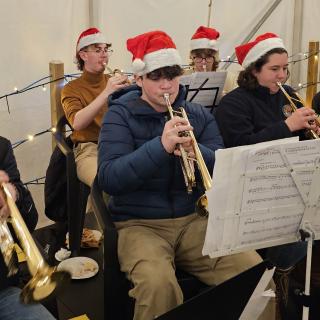 Musicians wearing 'Santa' hats playing brass instruments.