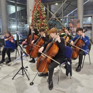 Children and young people playing string instruments at Christmas