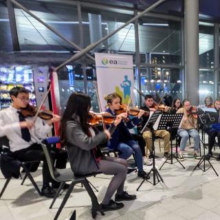 Children and young people playing string instruments at Christmas