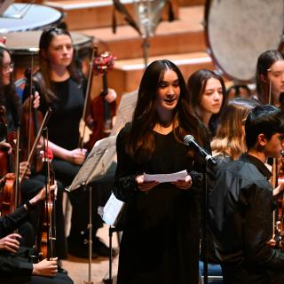 A young person introducing a concert in the Ulster Hall.