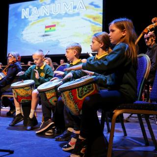 pupils performing on African drums on stage during Springfest