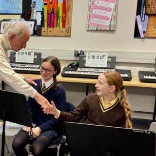 Phil Coulter shaking hand with a student