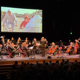 Western Region staff orchestra on stage in Millennium Forum at Sprinfgfest