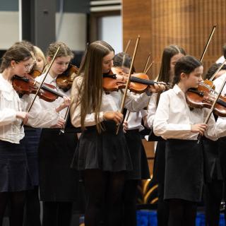 Young string players performing in a concert