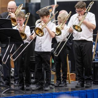 Young trombone section performing in a concert
