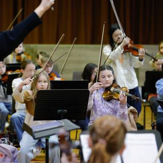 Young musicians performing in a string orchestra rehearsal
