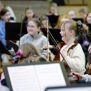 Young musicians performing in a string orchestra rehearsal