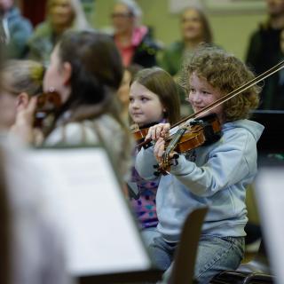Young string players performing in a concert