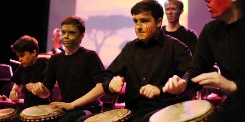 Image of African drumming workshop featuring pupils with facepaint