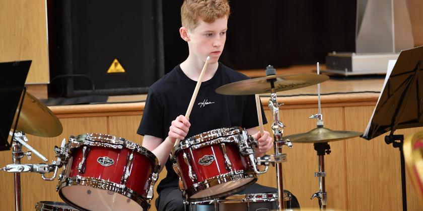 Drum kit being played in youth band concert