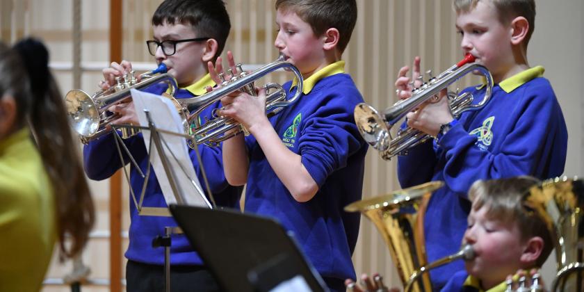 Three primary school cornet players in concert