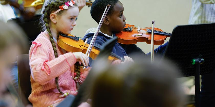 Young musicians performing in a string orchestra rehearsal